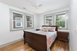 Bedroom with hardwoods floors and 4 large windows