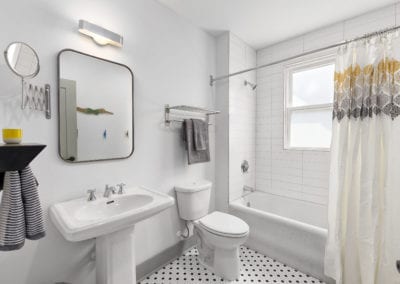 Bathroom with pedistal sink and tile floors. Shower/tub unit.